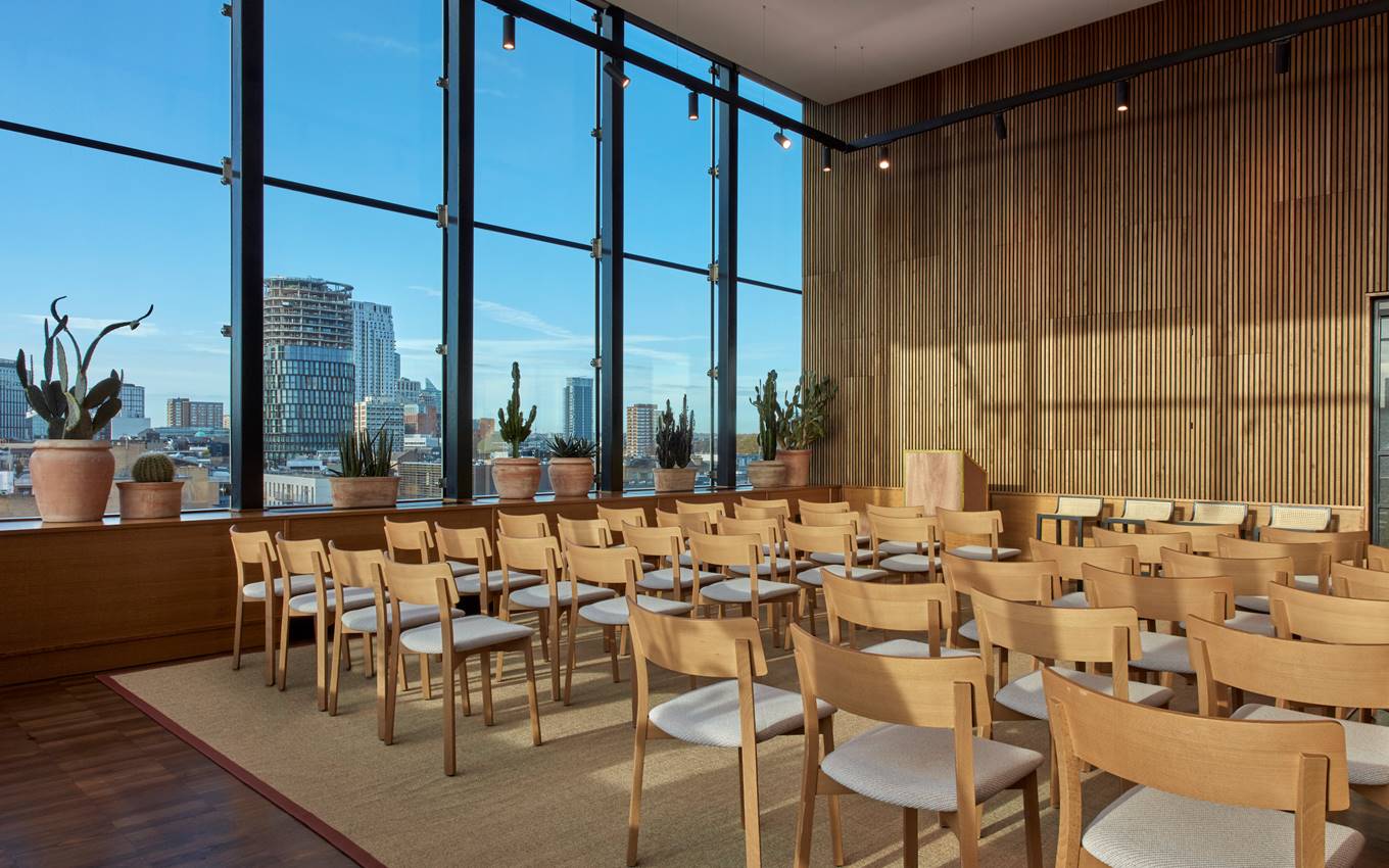 A spacious dining room featuring large windows that offer a panoramic view of the city skyline.