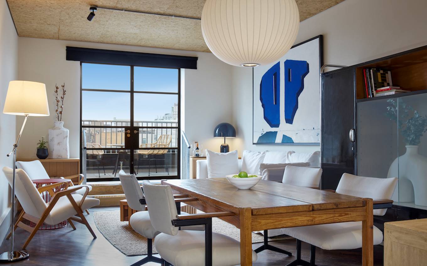 A modern living room featuring a table surrounded by chairs, creating an inviting space for gatherings and relaxation.