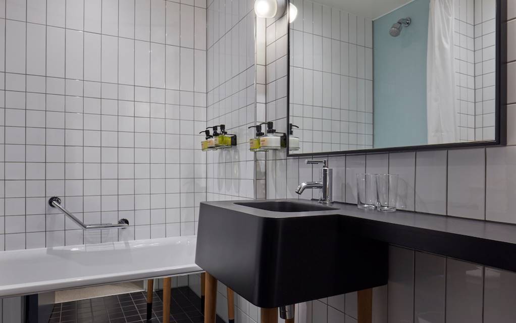 Elegant bathroom showcasing a black and white tiled wall, enhancing the contemporary design of the space.