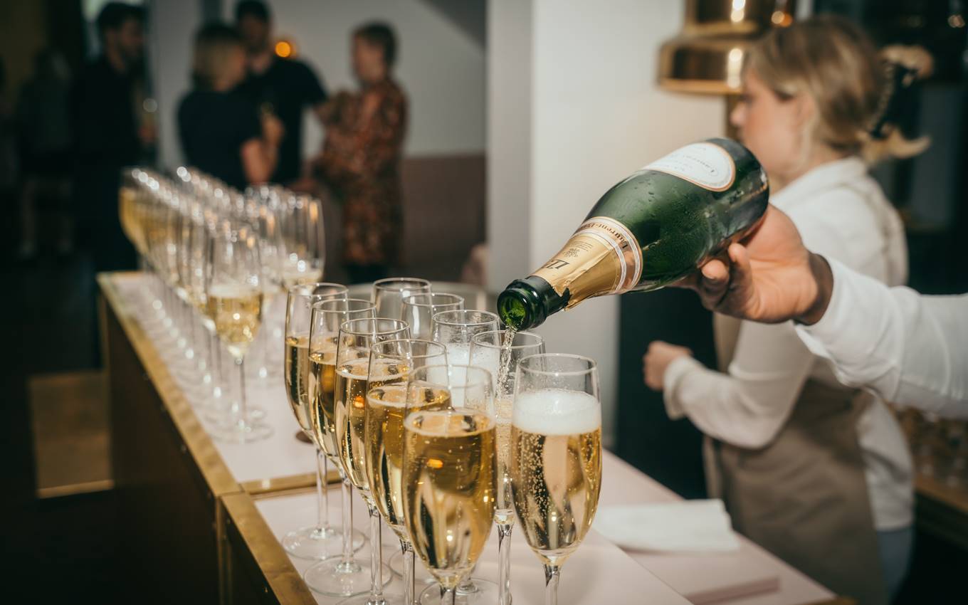 Champagne being elegantly poured into glasses, capturing the festive atmosphere of a lively party celebration.