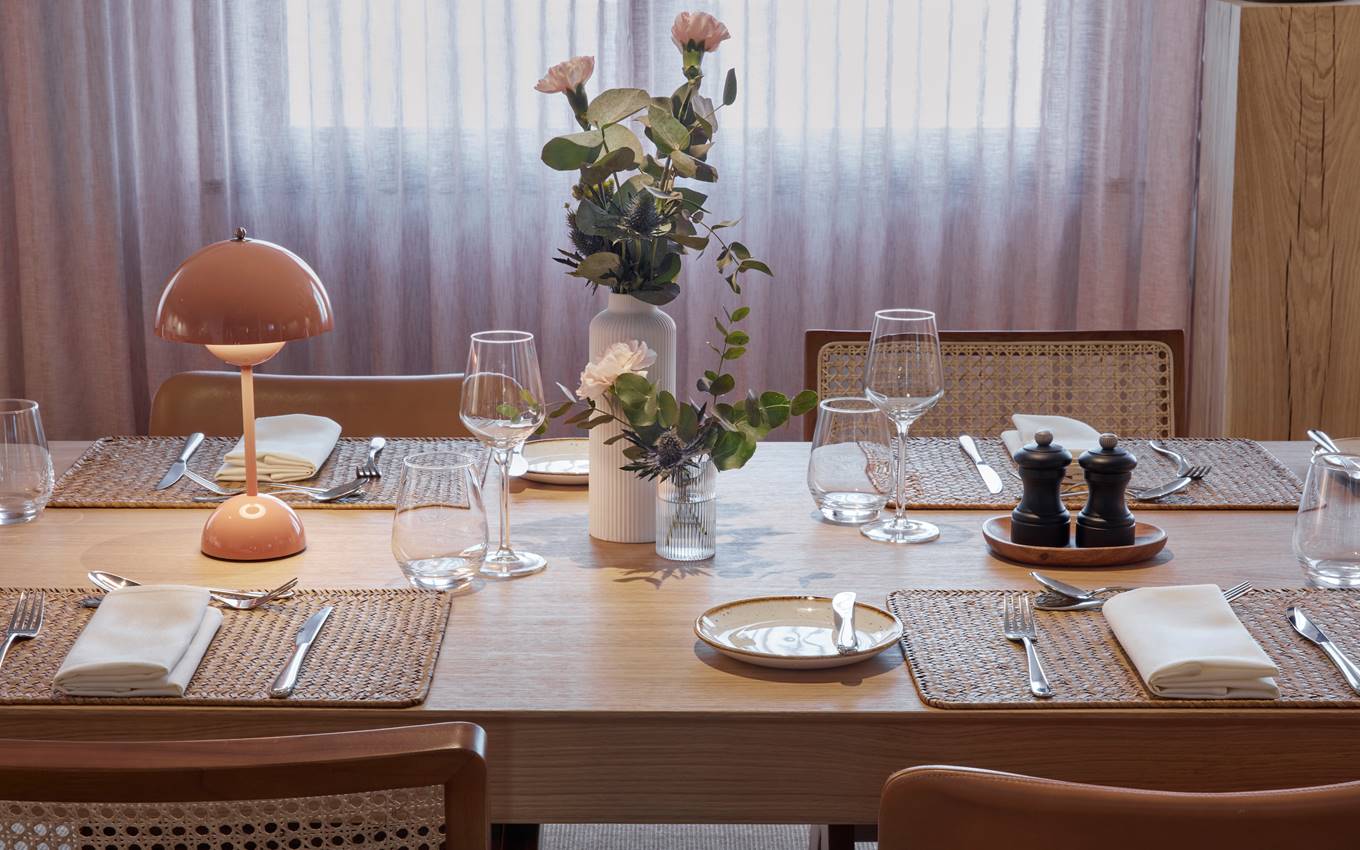 A beautifully arranged table featuring an elegant place setting and a vase filled with vibrant flowers.