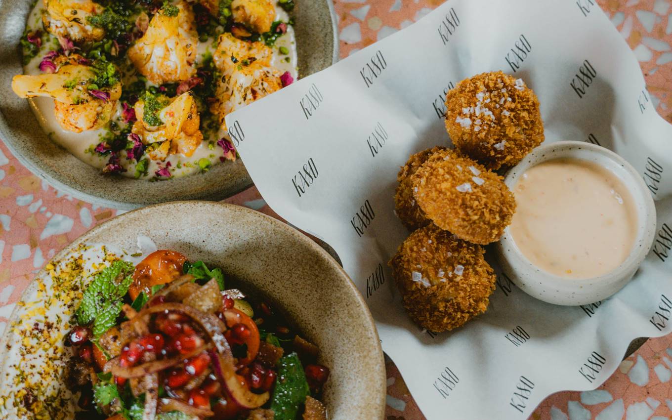 Crispy golden croquettes with flaky sea salt, served with a creamy dipping sauce alongside colourful salads at Kaso.