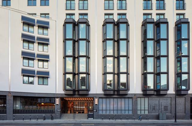 Exterior of One Hundred Shoreditch Hotel, showcasing its unique, protruding glass windows and modern architectural design.