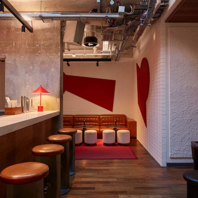A bar featuring red and white walls, complemented by stylish stools for a vibrant and inviting atmosphere.