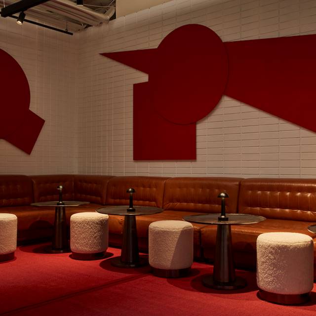 A bar featuring red and white walls, complemented by stylish stools for a vibrant and inviting atmosphere.