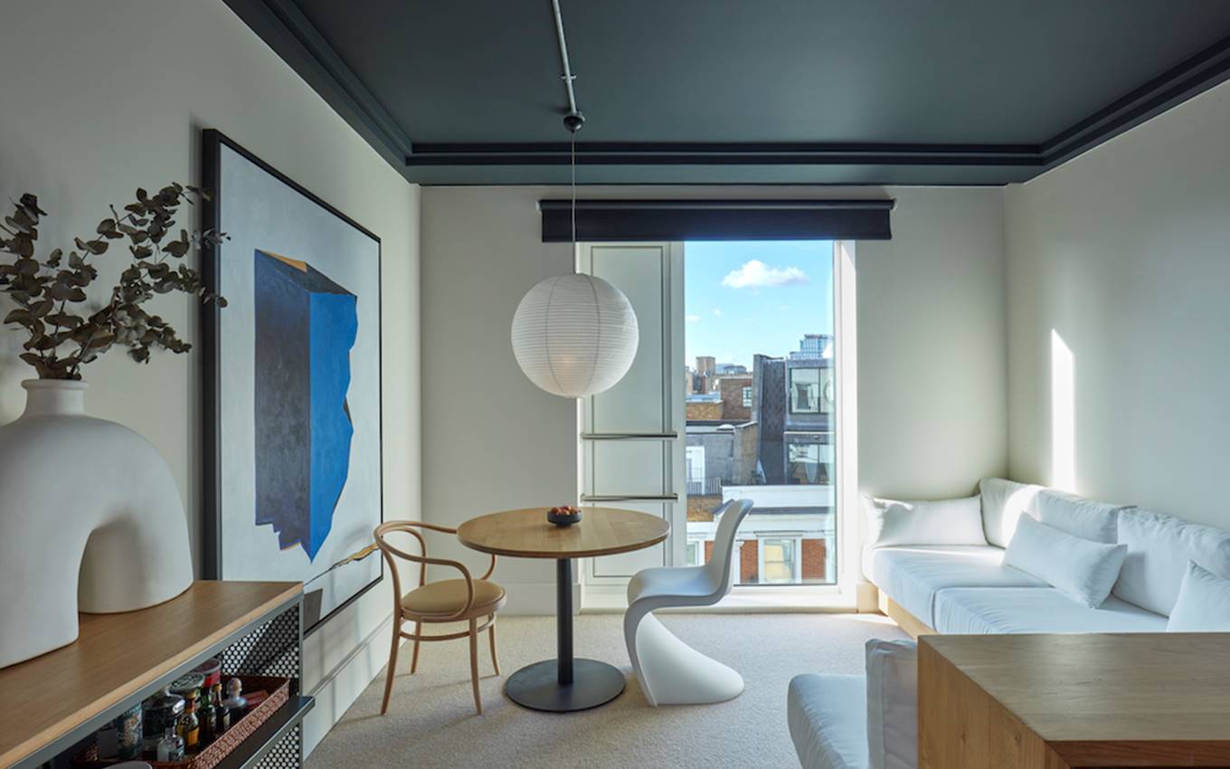 A contemporary studio room showcasing a white couch paired with a sleek table, emphasising comfort and elegance.