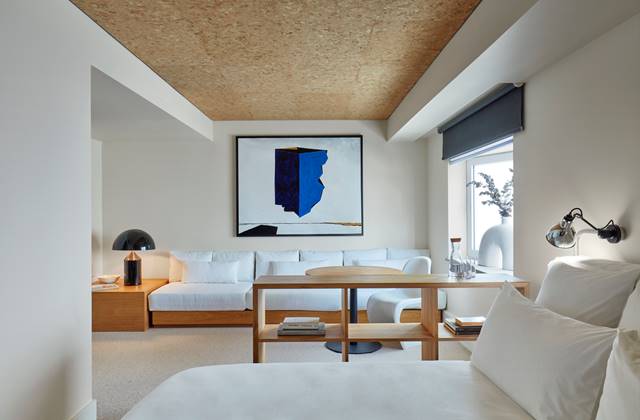 A white couch and a table are arranged in a cosy room, creating a welcoming and stylish atmosphere.