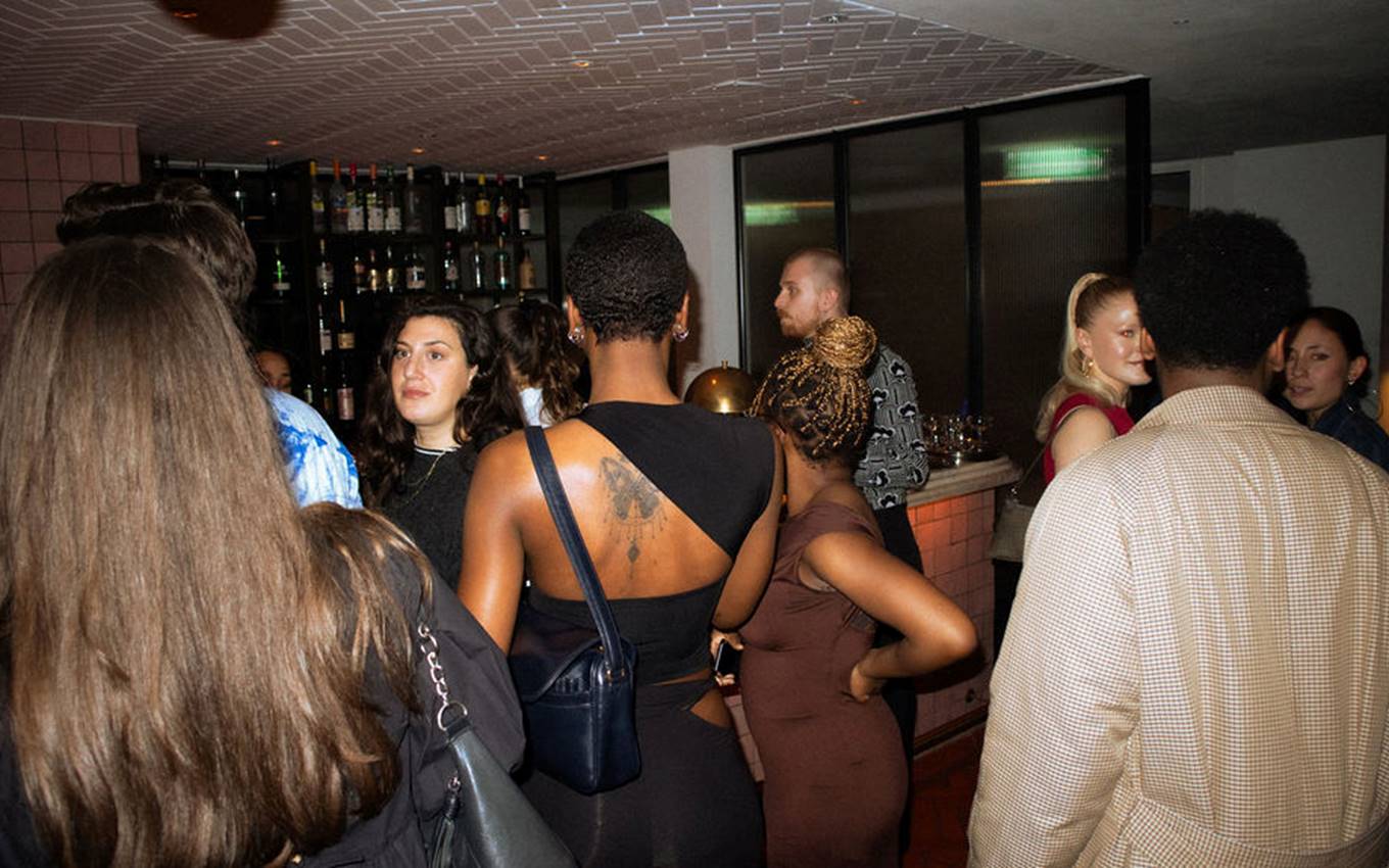 A diverse group of individuals socializing and enjoying drinks together in a lively bar setting.