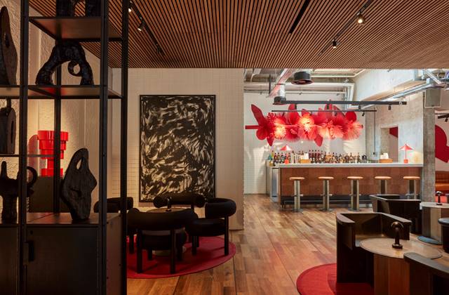 A contemporary bar featuring striking red and black artwork adorning the walls, creating a vibrant atmosphere.