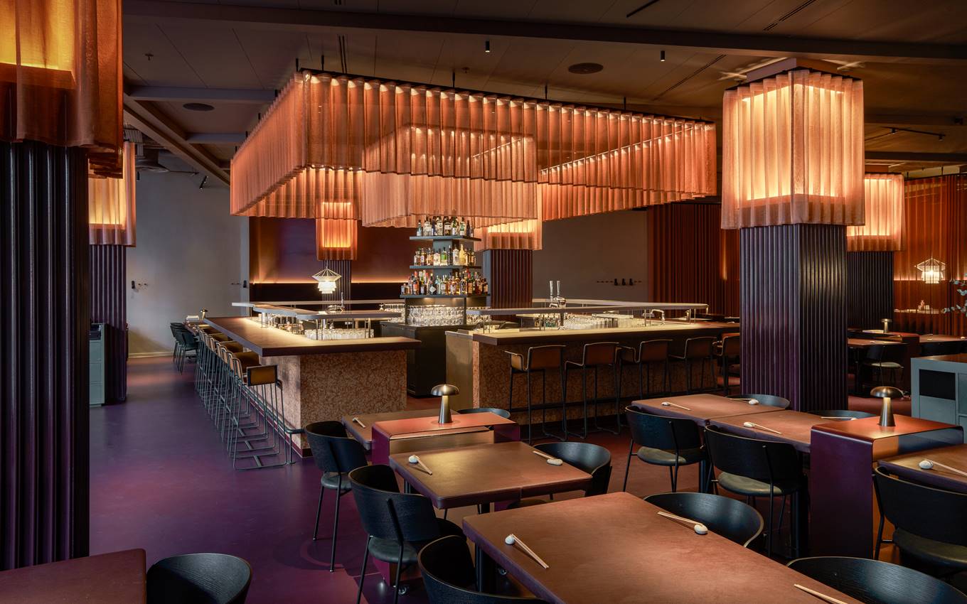 Elegant bar and dining area at One Hundred Shoreditch, featuring warm lighting and a modern aesthetic.