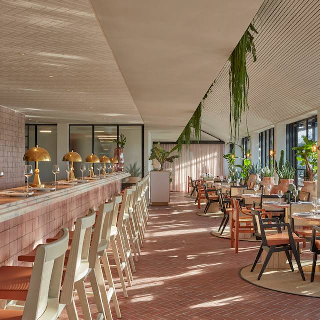 A hotel bar elegantly surrounded by lush greenery, creating a serene and inviting atmosphere for guests.